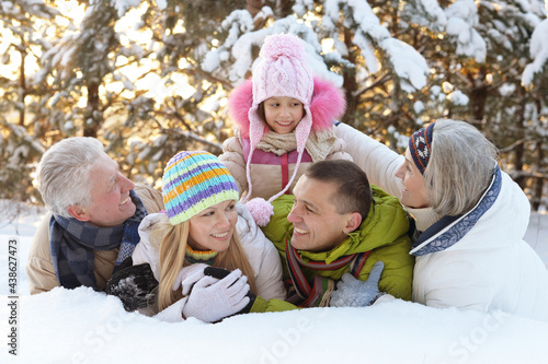 Big happy family having fun in winter park covered with snow