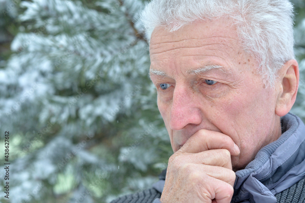 Portrait of sad senior man standing outdoors in winter Portrait of sad senior man standing outdoors in winter