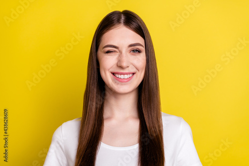 Portrait of attractive cute cheerful girl winking you isolated over vibrant yellow color background © deagreez