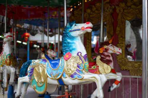 merry-go-round wooden horses, Carousel Horse with traditional paintwork. Beautiful horse Christmas carousel in a holiday park. Two horses on a traditional fairground vintage carousel. Merry-go-round