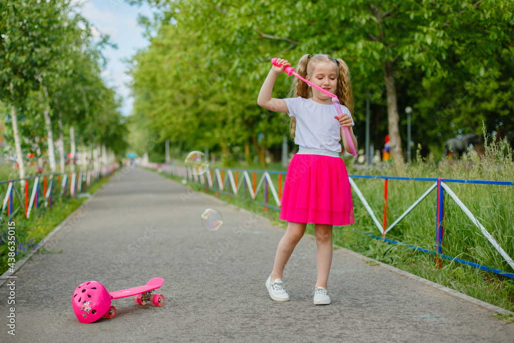 little girl blows soap bubbles in the Park in the summer Stock Photo ...