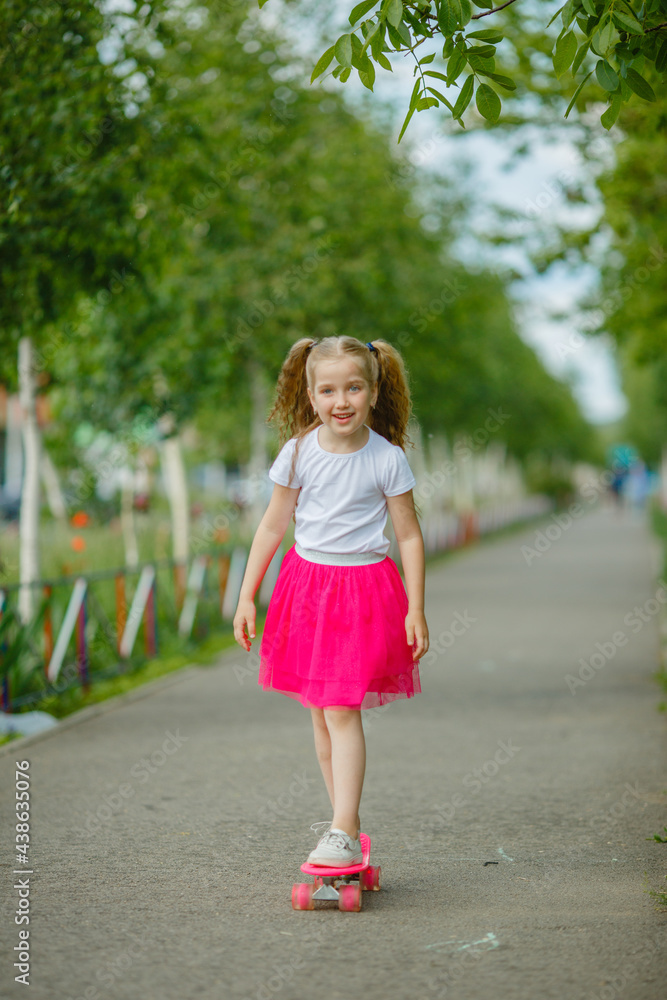 cute little girl skateboarding in the park in summer cute little girl skateboarding in the park in summer