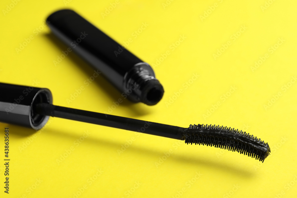 Mascara for eyelashes on yellow background, closeup. Makeup product Mascara for eyelashes on yellow background, closeup. Makeup product