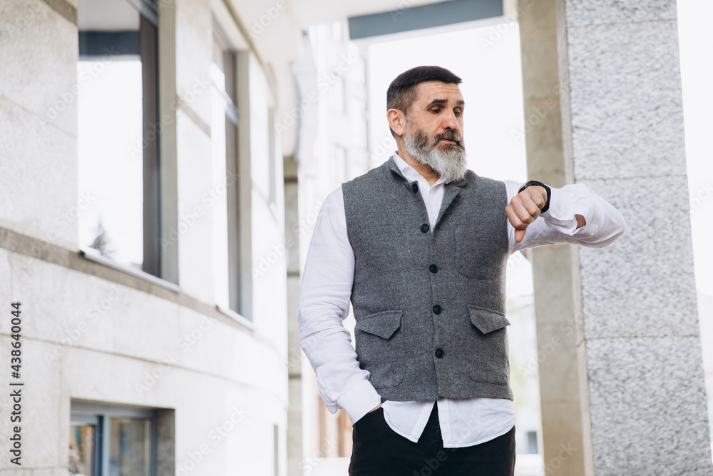 Portrait of a gray bearded and brutal man spending time on the clean streets of the city. Portrait of a gray bearded and brutal man spending time on the clean streets of the city.