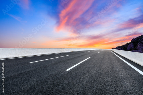 Asphalt highway and colorful cloud scenery at sunrise.