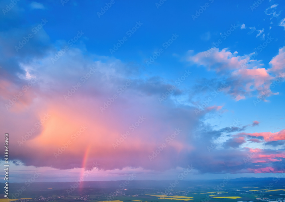 Evening, vibrant sky, pink violet blue clouds lit by setting sun. Huge rainbow over agriculture landscape. Aerial view, far horizon, ideal for sky replacement process. Evening, vibrant sky, pink violet blue clouds lit by setting sun. Huge rainbow over agriculture landscape. Aerial view, far horizon, ideal for sky replacement process.