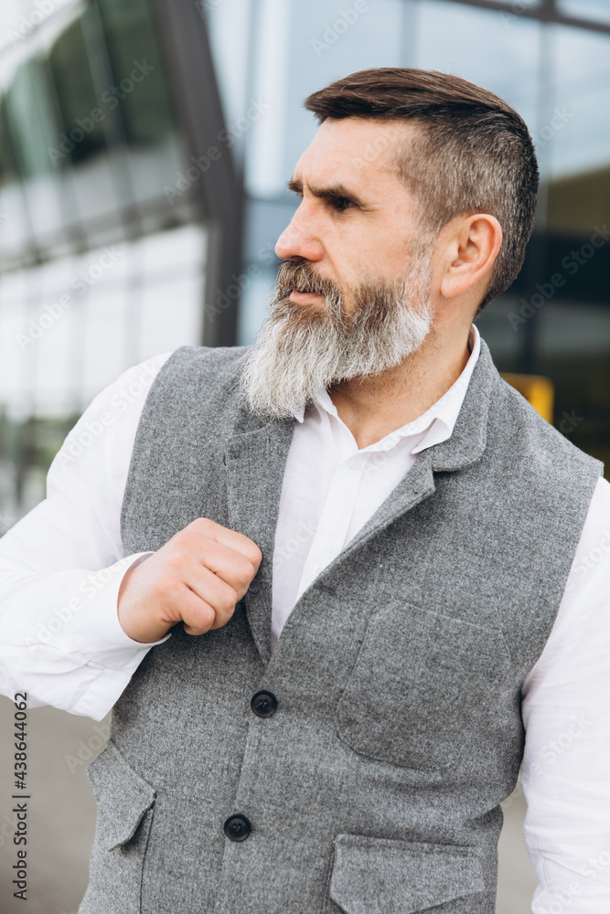 Naklejka premium Portrait of a gray bearded and brutal man spending time on the clean urban spaces.