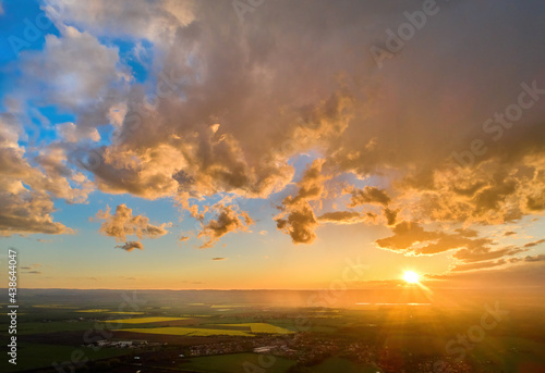 Colorful sky background sunset, illuminated pink-orange dramatic clouds, aerial photography, far horizon, setting sun. Ideal for sky replacement postproces.