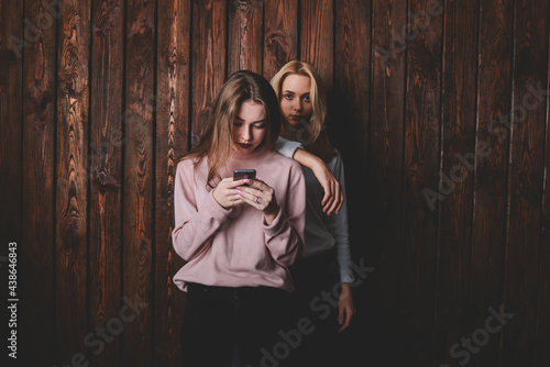 Young pensive woman leaning on shoulder of girlfriend