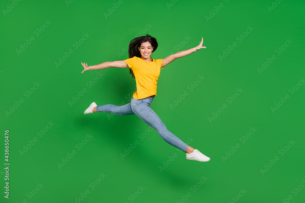 Full length body size side profile photo dreamy girl brunette ballerina jumping high smiling isolated vibrant green color background