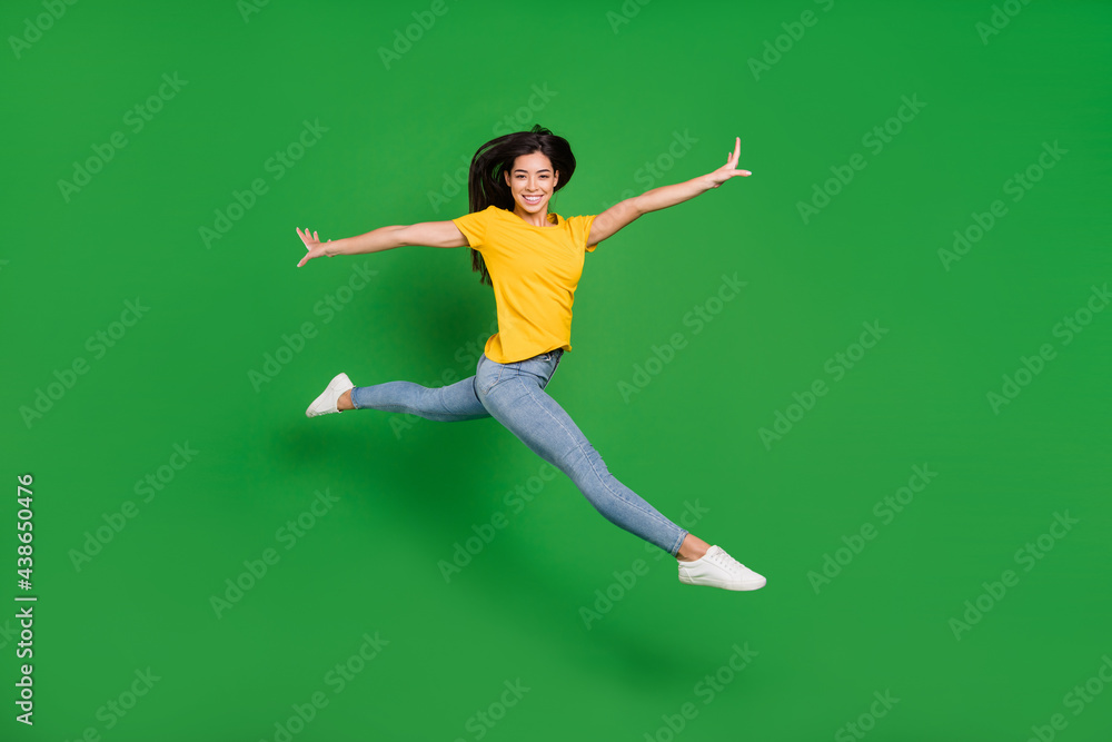 Full length body size side profile photo dreamy girl brunette ballerina jumping high smiling isolated vibrant green color background Full length body size side profile photo dreamy girl brunette ballerina jumping high smiling isolated vibrant green color background