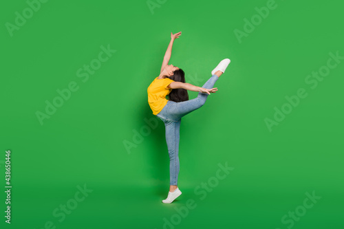 Full size photo of cheerful nice young woman jump up ballet dancer good mood isolated on green color background