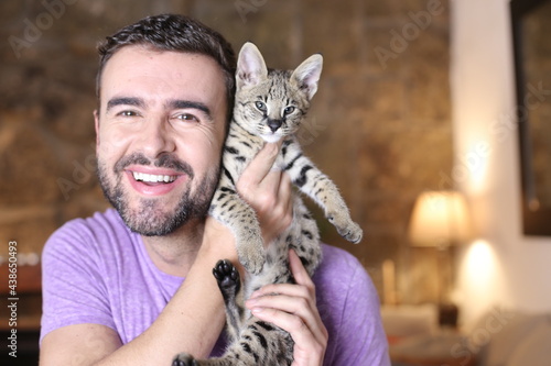 Fototapeta Naklejka Na Ścianę i Meble -  Cute guy and stunning hybrid cat 