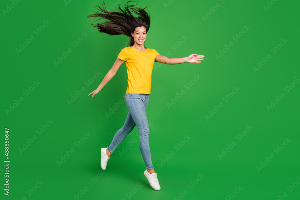 Full length body size photo dreamy girl brunette hair jumping up smiling isolated vivid green color background Full length body size photo dreamy girl brunette hair jumping up smiling isolated vivid green color background