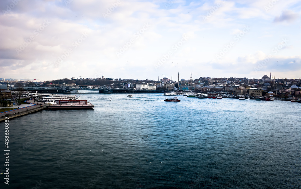 Istanbul Golden Horn view. Cloudy sky, ferries, pier and sea. Istanbul's historical landmarks and mosques.