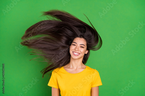 Photo of positive young charming woman fly hair hairstyle smile good mood isolated on green color background photo