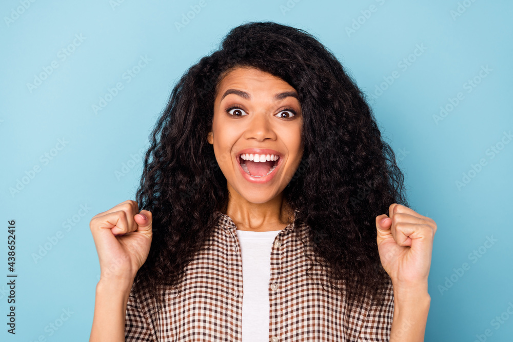Photo of celebrate curly hairdo millennial lady hands fists open mouth wear brown shirt isolated on vivid blue color background Photo of celebrate curly hairdo millennial lady hands fists open mouth wear brown shirt isolated on vivid blue color background