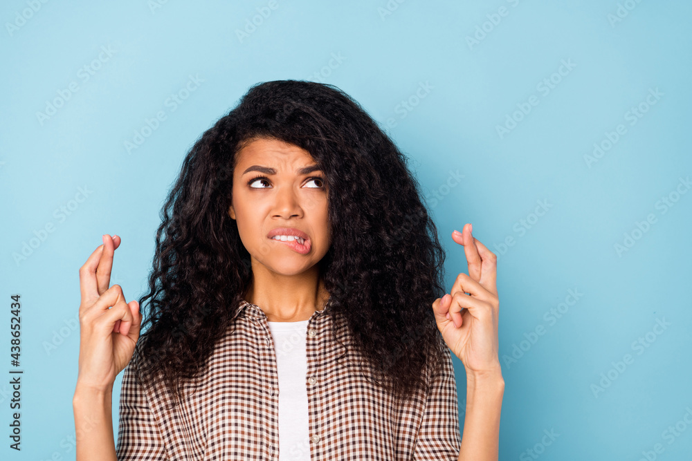 Photo of worried curly hairdo young lady crossed fingers look empty space wear brown shirt isolated on vivid blue color background Photo of worried curly hairdo young lady crossed fingers look empty space wear brown shirt isolated on vivid blue color background