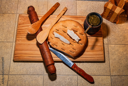 Mate, hot infusion typical of Argentina, Uruguay, southern Brazil and Paraguay with by delicious freshly baked artisan bread, nutritious, homemade, fresh and healthy wheat flour, on a wooden board.