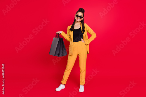 Full size photo of cute lady with bags wear yellow blazer isolated on vivid red color background