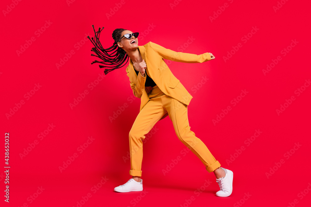 Full length photo of funny lady dance wear eyewear yellow suit isolated on vivid red color background Full length photo of funny lady dance wear eyewear yellow suit isolated on vivid red color background