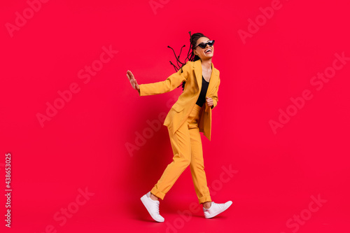 Full body profile photo of nice lady go wear eyewear yellow suit isolated on vivid red color background