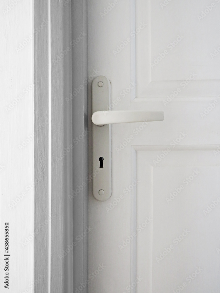 Knob and handle detail on exterior white door. White lock on closed gate. Classic doorhandle on closed wooden door. Architecture and Construction Knob and handle detail on exterior white door. White lock on closed gate. Classic doorhandle on closed wooden door. Architecture and Construction
