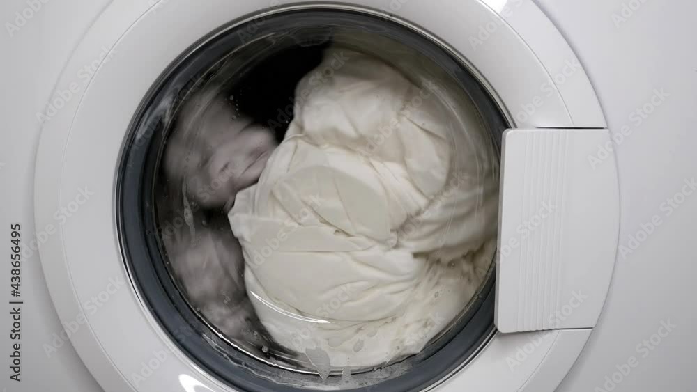 The washing machine is running. Washing of white bed linen. The washing machine is running. Washing of white bed linen.