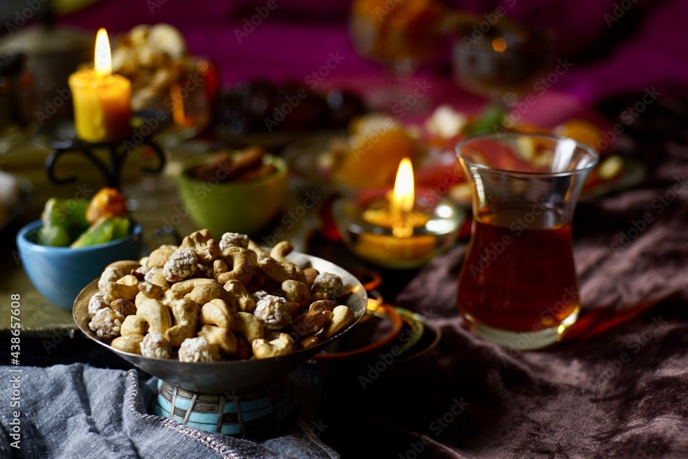 Nuts mix on a black table background with candles and turk lale with tea