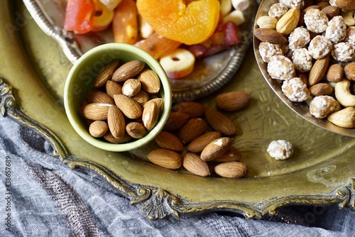 A table with Turkish tea with lale, oriental sweets, rahad delight, a mix of various nuts using copper dishes and bright fabrics. photo