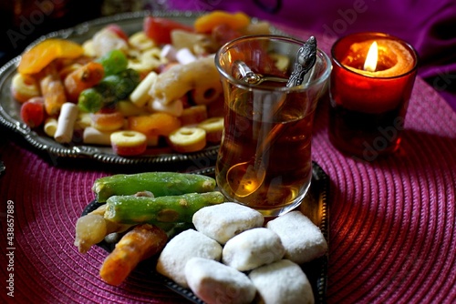 Black Turkish tea in lala with oriental sweets and dried fruits by candlelight photo