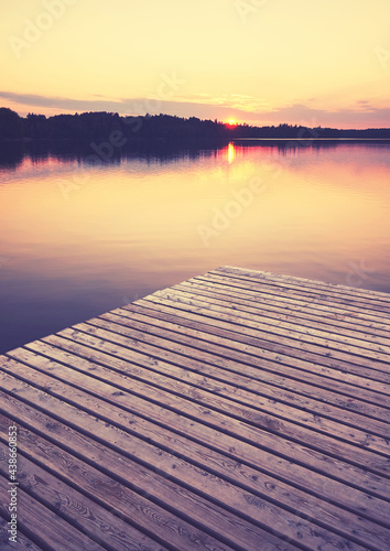 Wooden pier at golden sunset, selective focus, color toning applied, Strzelce Krajenskie, Poland.