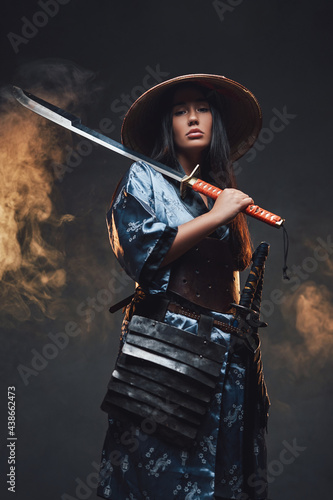 Asian woman with katana and kasa against smokey background