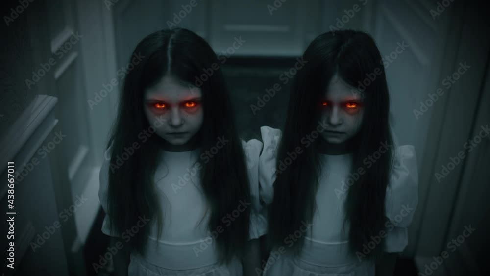 Evil twin girls with red beaming eyes staring into camera, witchcraft, horror. Paranormal events, ghost activity, horror scene