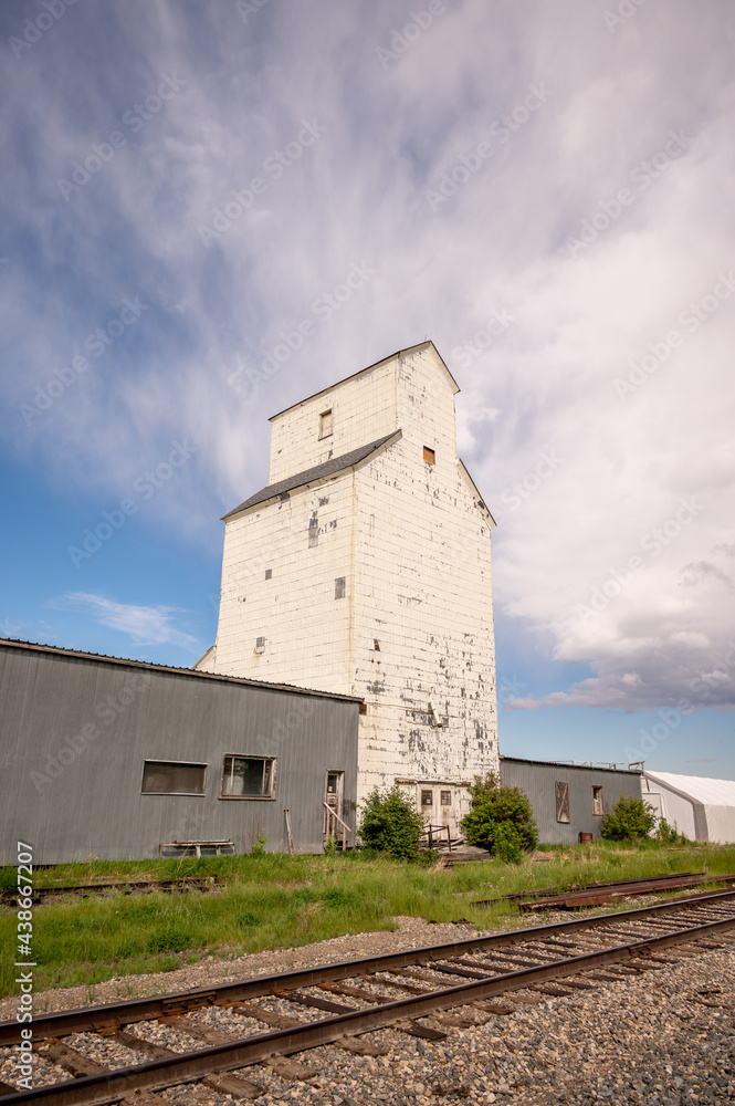 De Winton, Alberta - May 5, 2021: Old grain elevators outside the small town of De Winton, Alberta. De Winton, Alberta - May 5, 2021: Old grain elevators outside the small town of De Winton, Alberta.