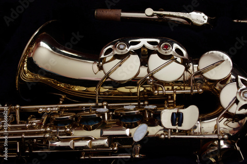 moody closeup of gold saxophone on black 