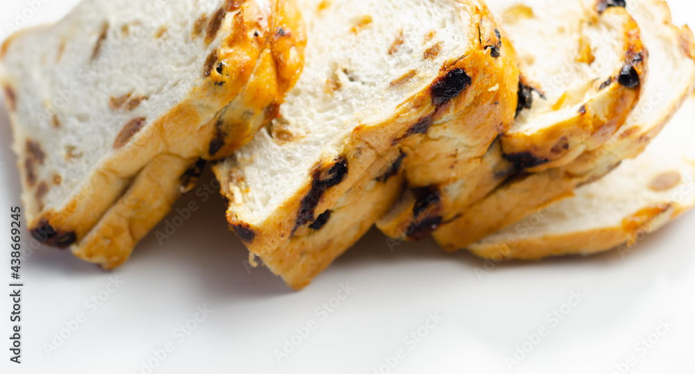 Fruit loaf with sultanas and orange flavored pieces on the white background Fruit loaf with sultanas and orange flavored pieces on the white background