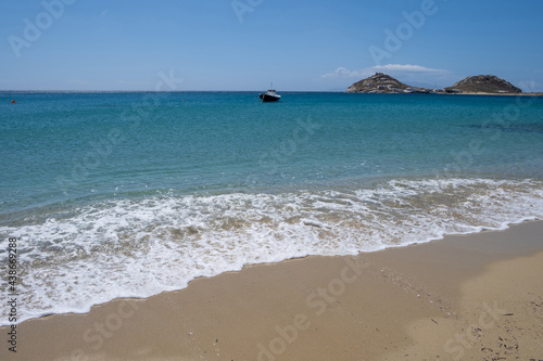 Greece, Cyclades. Traditional boat anchored on blue color sea water photo