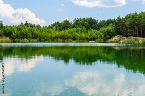 View on a lake in the abandoned sand quarry and dramatic sky