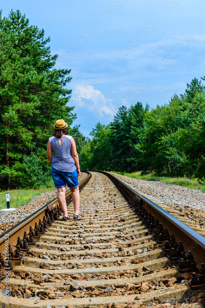 Lonely young woman on a railway in forest Lonely young woman on a railway in forest
