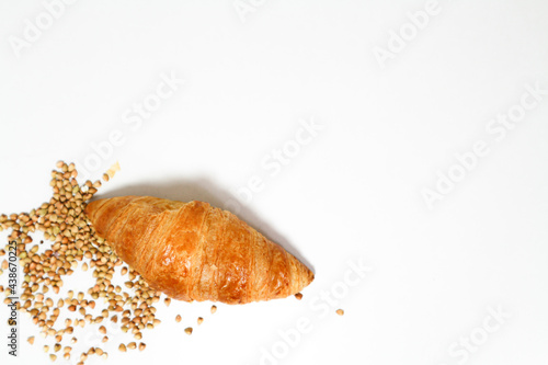 croissant and buckwheats on white background with copy space