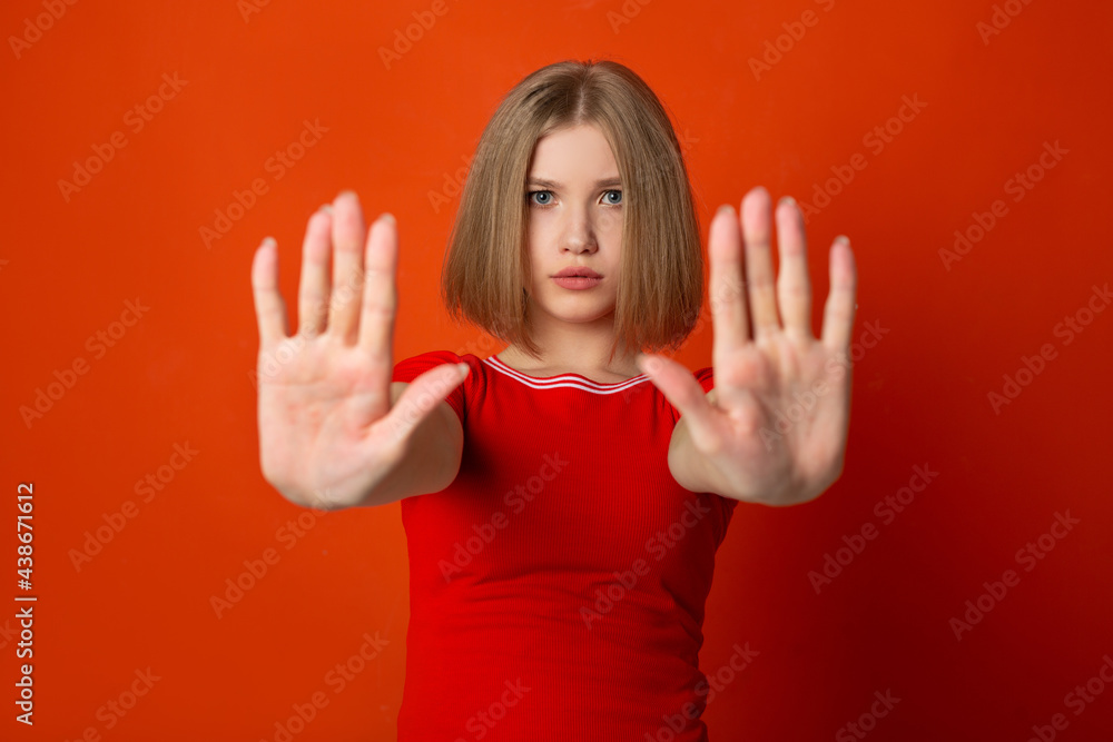 young woman in red t-shirt with hand gesture on red background young woman in red t-shirt with hand gesture on red background