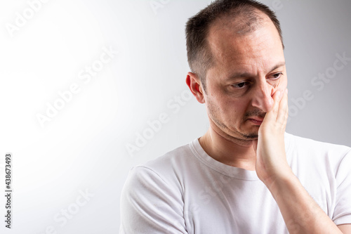 Depressed male model demonstrating negative reaction. Shocked troubled man, keeps hands on head, being shocked hearing bad news about relatives or friends.