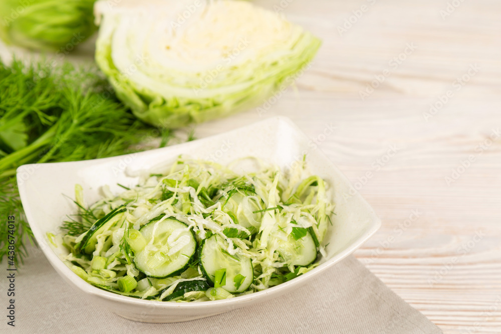 Salad with cucumber and cabbage in a white plate. Salad with cucumber and cabbage in a white plate.