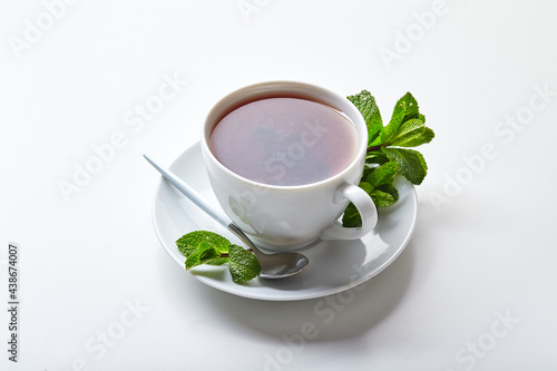Black tea in white cup with mint leaves. Soothing tea, anti-stress