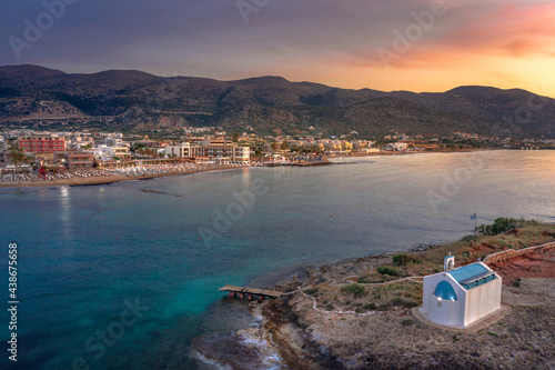 An old white church in a small island at sunset in Malia, Crete, Greece.