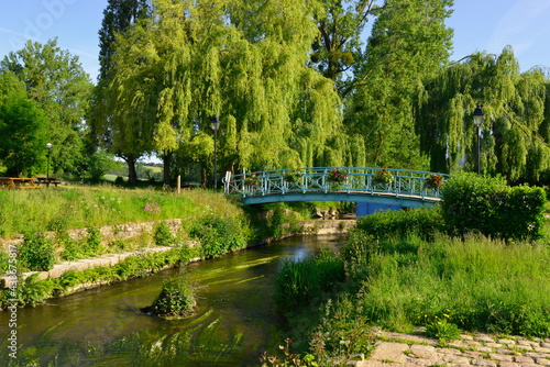 La Loisance traversée par un pont fleuri, coule dans un parc de verdure à Antrain (35560 Val-Couesnon), département d'Île-et-Vilaine en région Bretagne, France