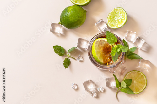 Cuba Libre alcoholic drink, Cola with ice cubes or lemonade on a pastel brown background. Top view flat lay background. Copy space.