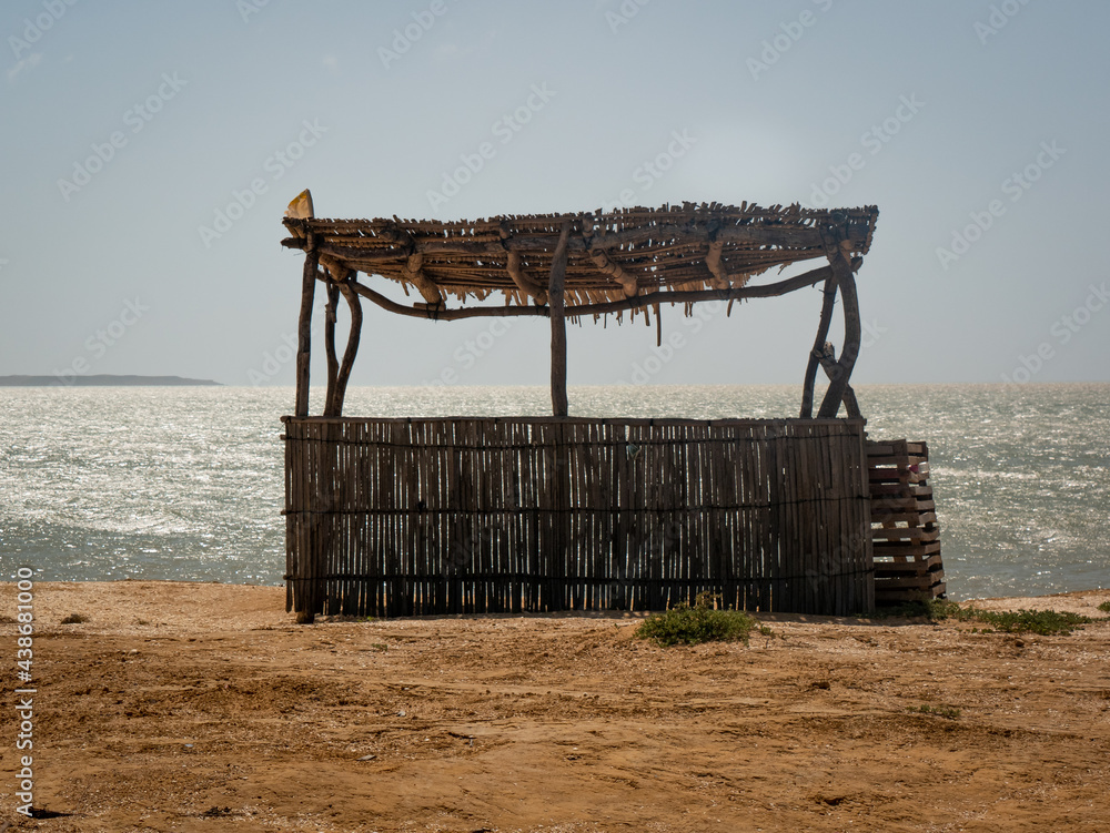 Fototapeta premium Background of the Sea at Bahia Honda Beach with a Ecological Little Store Made from Dried Banana Leaves and Logs in La Guajira, Colombia