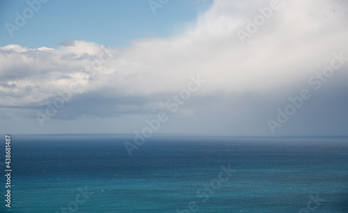 Sea with turquoise blue water and blue sky with white clouds. Seascape in winter